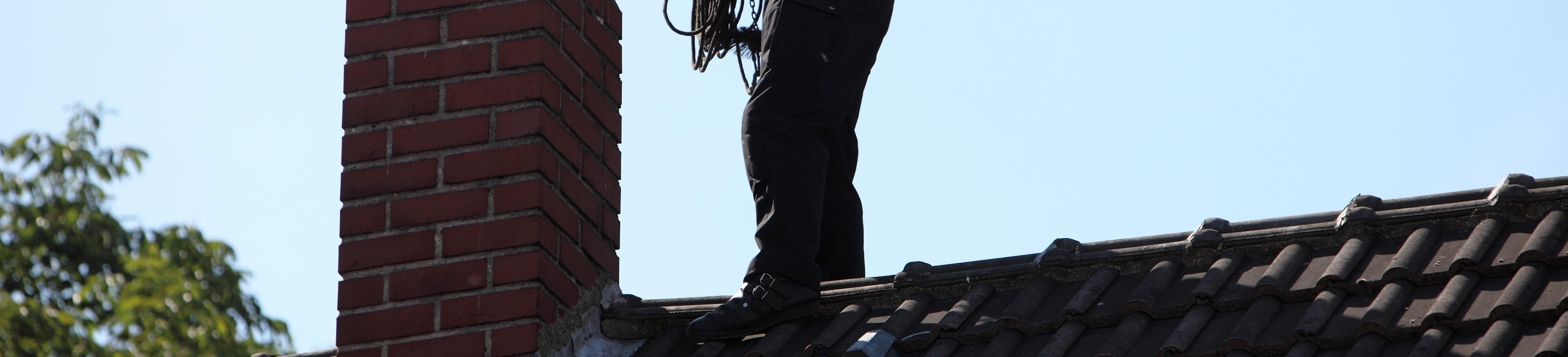 sweep on roof inspecting chimney