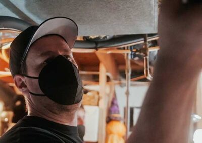 Tech wearing mask inspecting boiler flue relining.